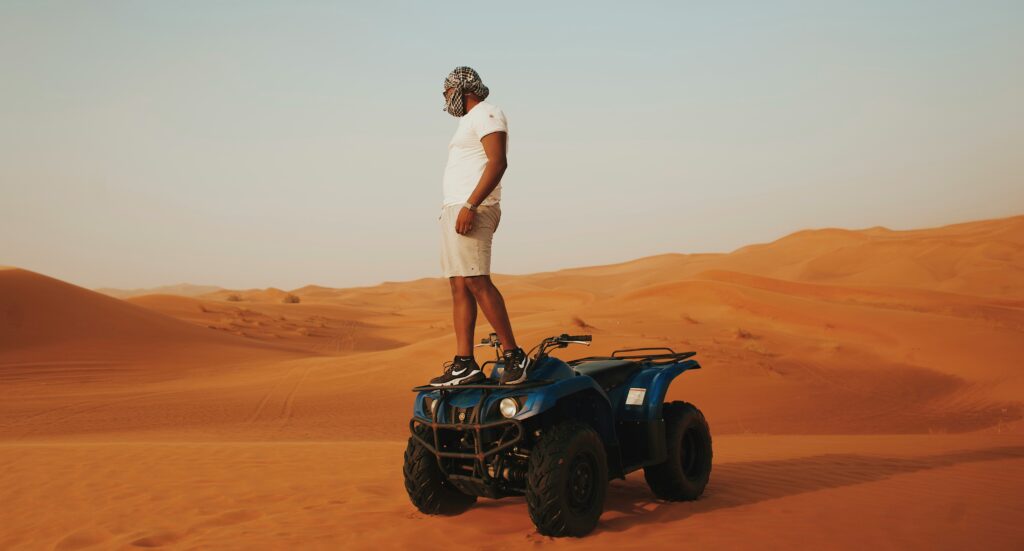 Lama Desert Safari Dubai A Man Standing on Four Wheeler Lama Desert Safari Dubai