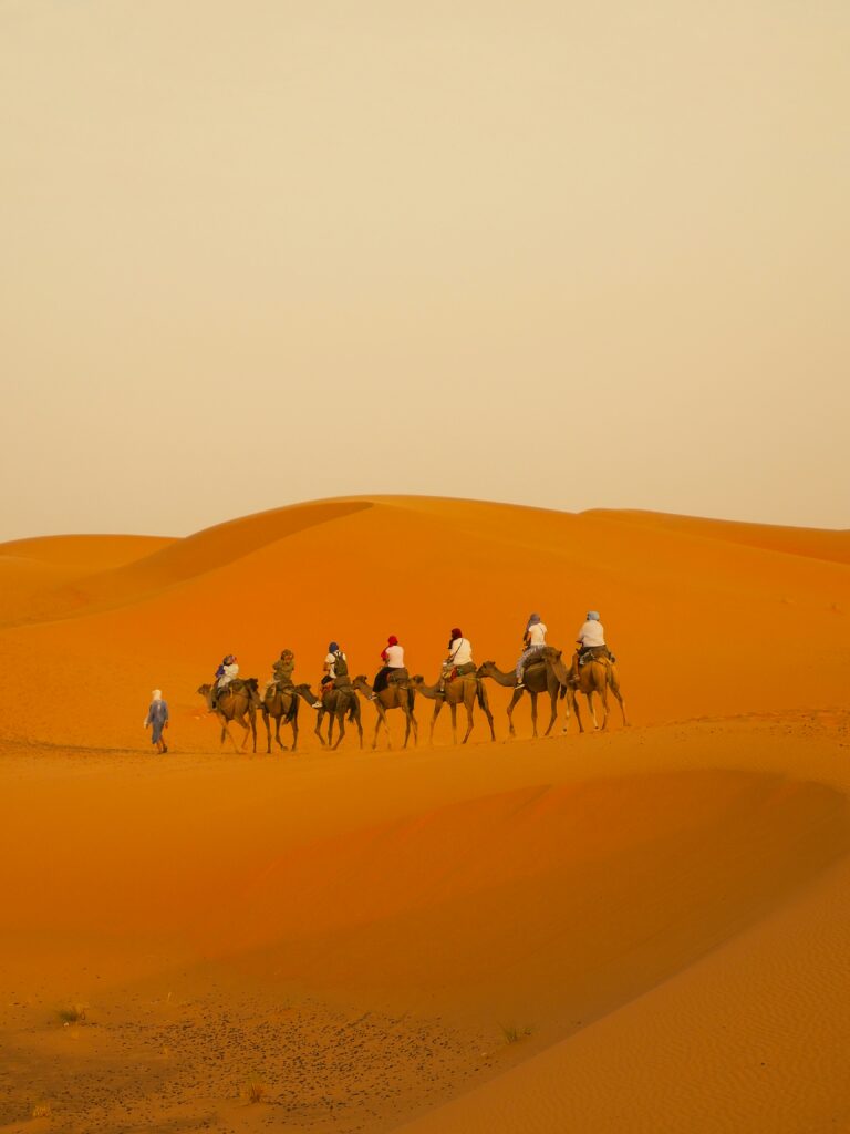 Experience the Ultimate Luxury Desert Safari in Dubai A Group of People Riding on Camels Experience the Ultimate Luxury Desert Safari in Dubai