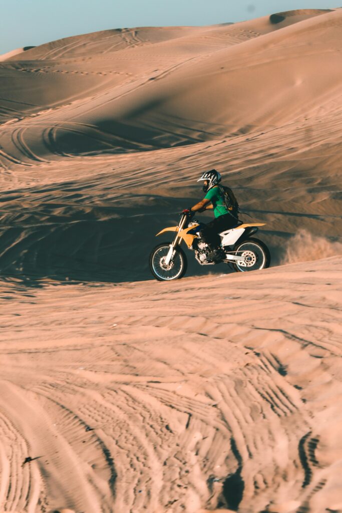 A Man Riding A Dirt Bike on Sand Dune Abu Dhabi